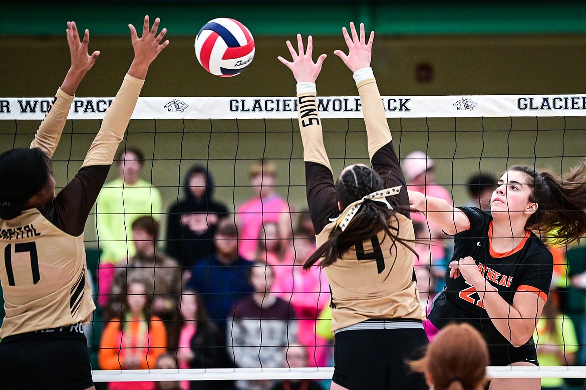 Flathead's Sienna Sterck (22) goes for a kill against Helena Capital's Tey'ana Lintner (17) and Kayla Almquist (4) during Round 1 of the Western AA Volleyball Tournament at Glacier High School on Thursday, Nov. 4. (Casey Kreider/Daily Inter Lake)