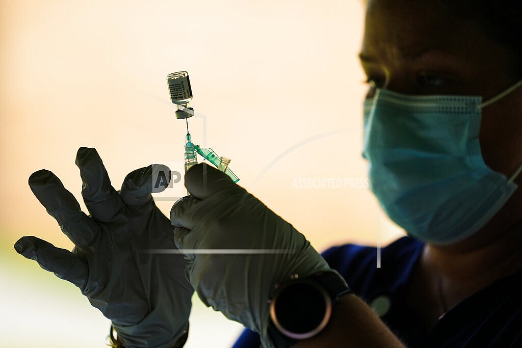 In this Sept. 14, 2021, file photo, a syringe is prepared with the Pfizer COVID-19 vaccine at a clinic at the Reading Area Community College in Reading, Pa. Millions of U.S. workers now have a Jan. 4 deadline to get a COVID vaccine. The federal government on Thursday, Nov. 4, 2021 announced new vaccine requirements for workers at companies with more than 100 employees as well as workers at health care facilities that treat Medicare and Medicaid patients.. (AP Photo/Matt Rourke, File)