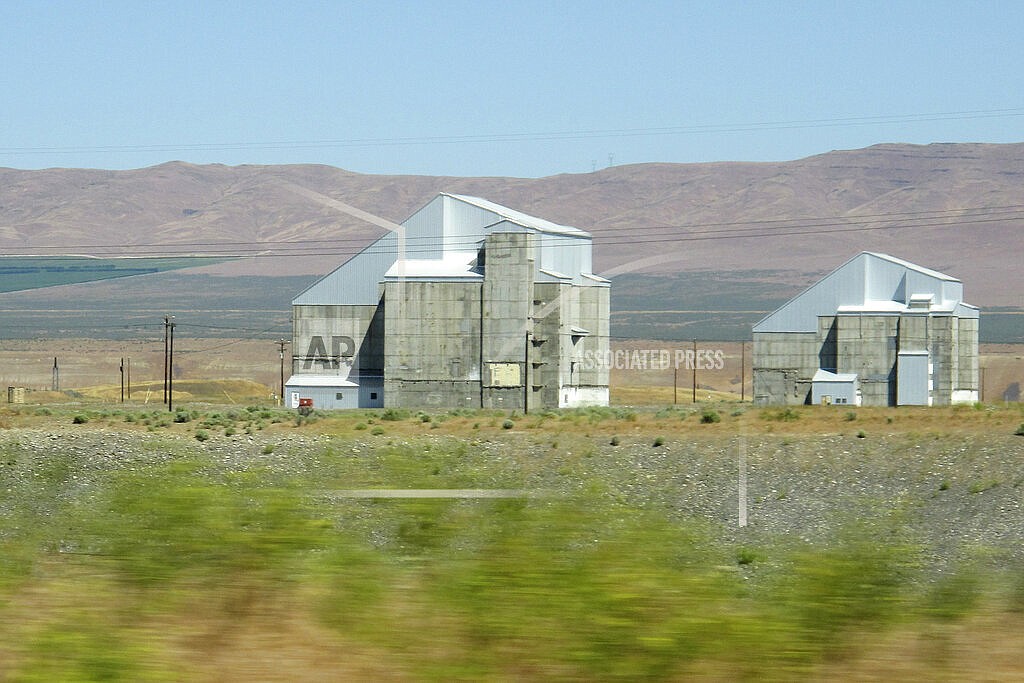 The decommissioned plutonium-producing DR reactor, left, and D reactor, right, are shown on the Hanford Nuclear Reservation, June 13, 2017, near Richland, Wash. The federal government is moving forward with the cost-saving "cocooning" of eight plutonium production reactors at Hanford that will place them in a state of long-term storage for decades to allow radiation inside to dissipate until they can be dismantled and buried. (AP Photo/Nicholas K. Geranios, File)