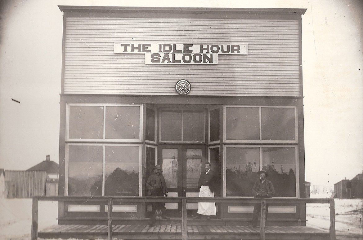 Idle Hour Saloon owner John Heuther (center) poses for a photo with a couple of unidentified patrons about 1910.