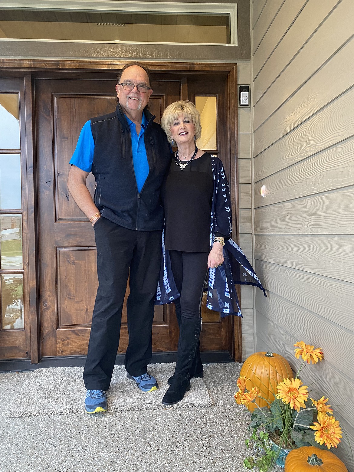 Steve and Lynn Rinker stand in front of their re-built home. Still in the process of putting things back together and replacing lost items, both are extremely grateful to be back home. A former construction worker with Viking Construction, Steve did a lot of the re-build himself.