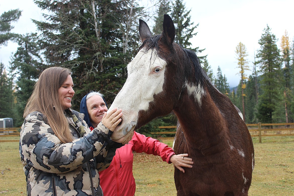 Spot to Talk Clinical Director and owner Claire Wick, left, and Equine Specialist Erica Gerber are pictured with one of their therapy horses. (Taylor Inman/Bigfork Eagle)