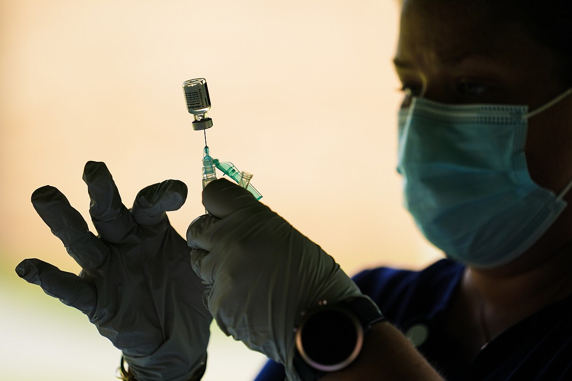 A syringe is prepared with the Pfizer COVID-19 vaccine at a clinic at the Reading Area Community College in Reading, Pa.