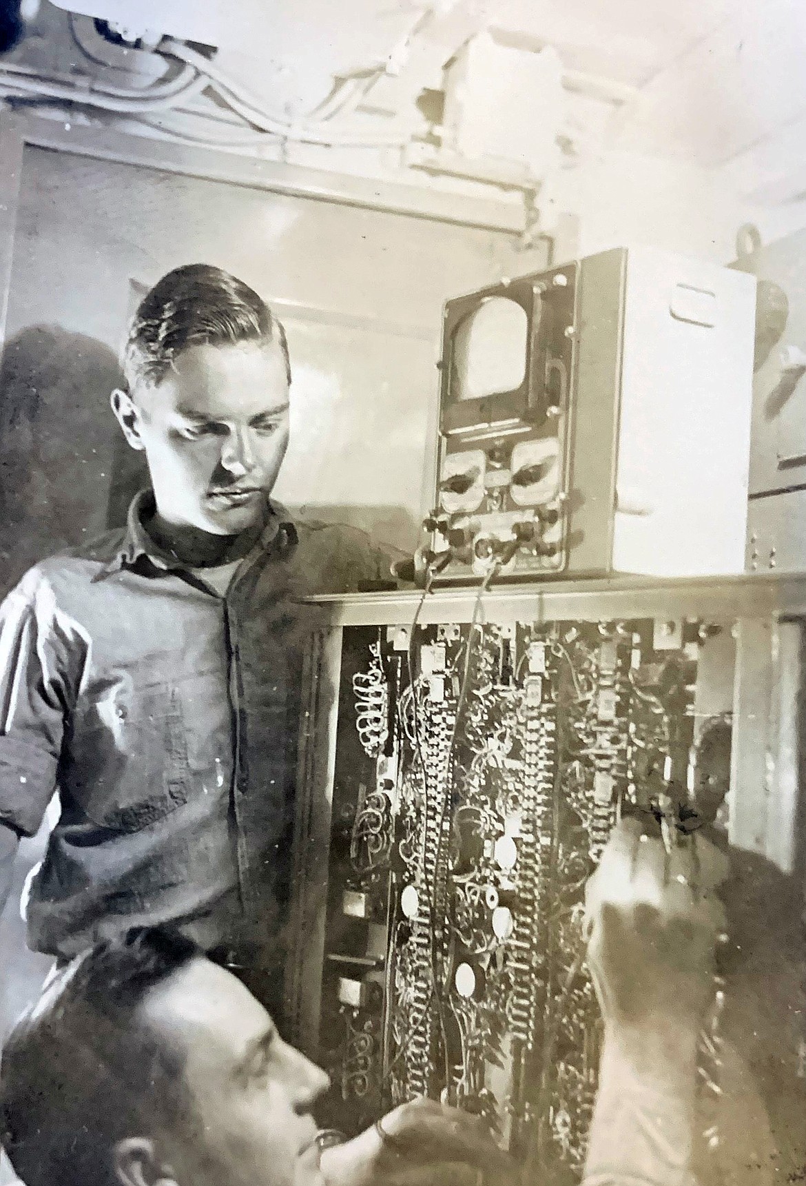 Arnold Peterson oversees repairs to the ship's radio aboard the destroyer U.S.S. Healy during World War II. (photo provided)
