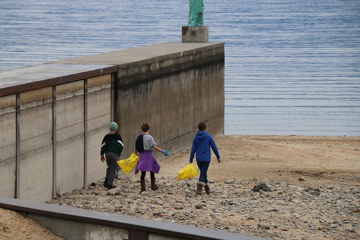 A trio walks along the pier at City Beach looking for trash and litter to pick up during Lake Pend Oreille Waterkeeper's annual cleanup.