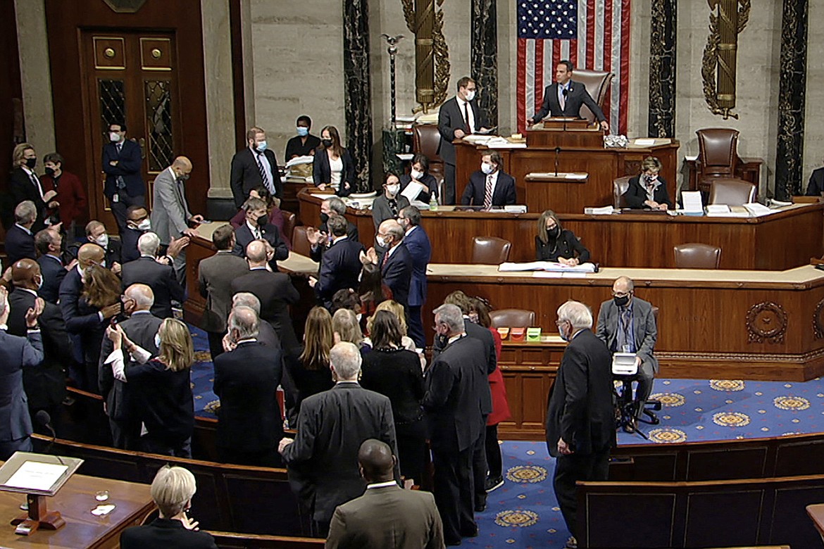 In this image from House Television, Democrats celebrate on the House floor late Friday, Nov. 5, 2021, in Washington, after the House approved a $1 trillion package of road and other infrastructure projects.