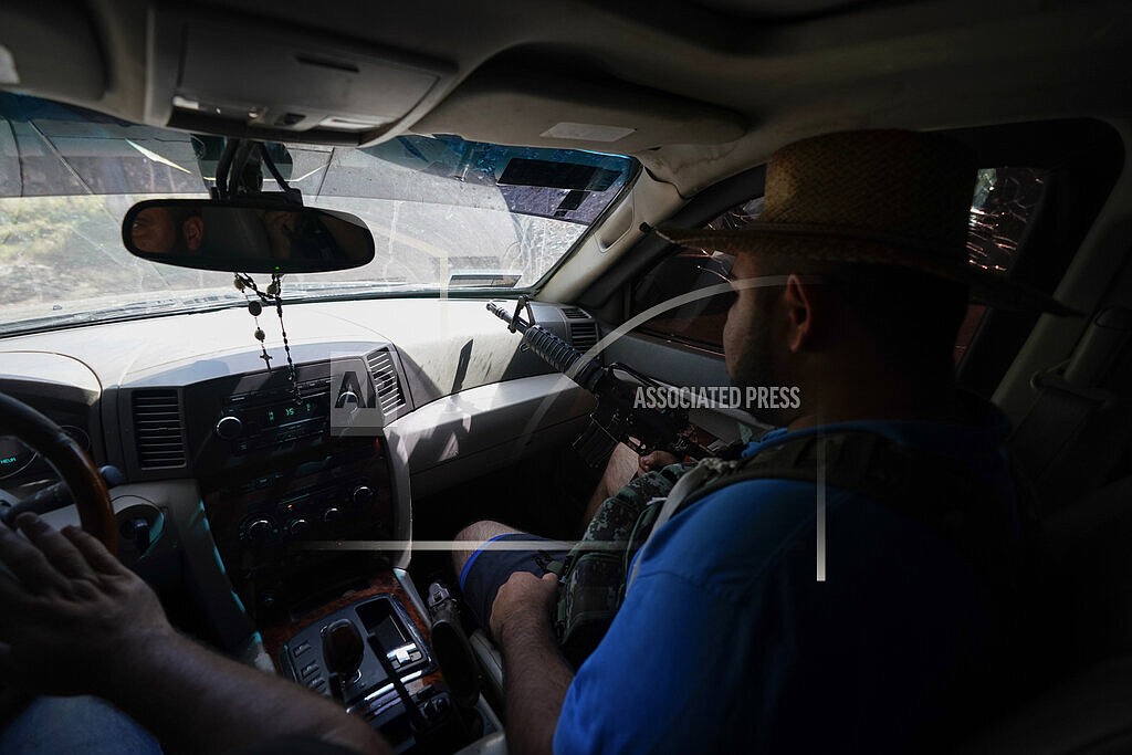 Armed men who claim to be members of a “self-defense” squad patrol the limits of Taixtan, in the Michoacan state of Mexico, Thursday, Oct. 28, 2021. The army has largely stopped fighting drug cartels here, instead ordering soldiers to guard the dividing lines between gang territories so they won’t invade each other’s turf _ and turn a blind eye to the cartels’ illegal activities. (AP Photo/Eduardo Verdugo)