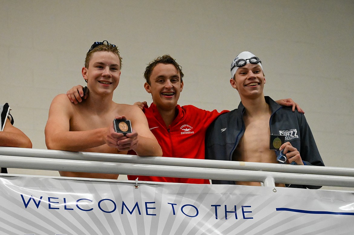 Caleb Norling (center) poses for a photo after capturing second in the 200 free.