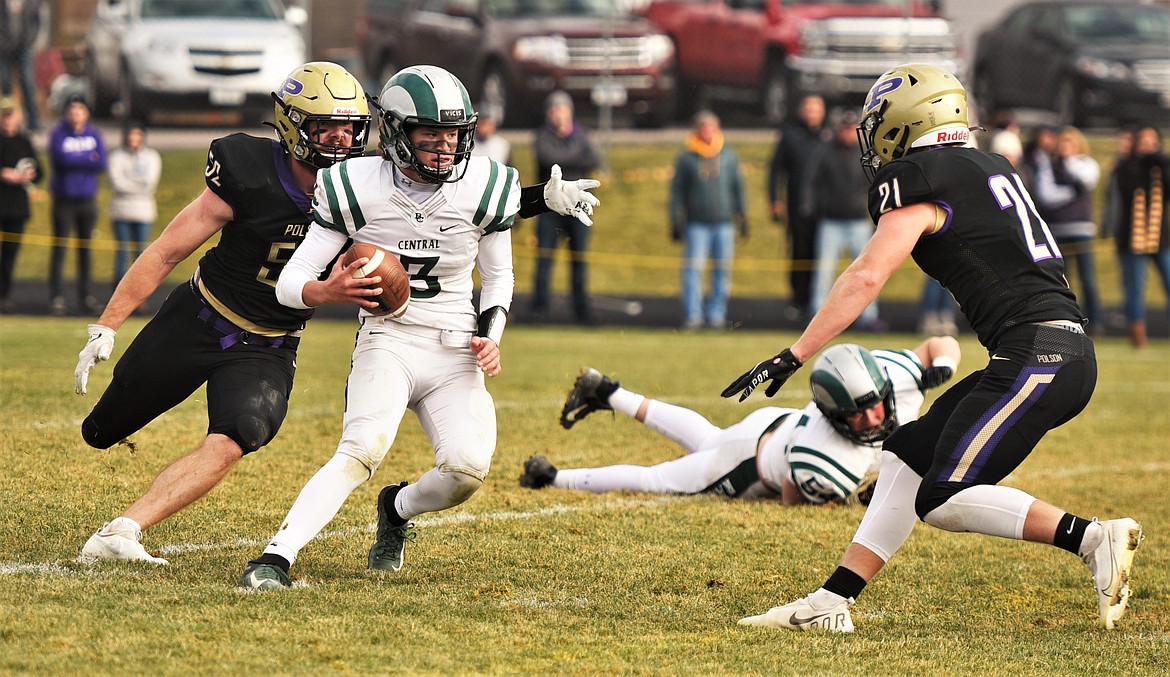 Polson defenders Braunson Henriksen (52) and Dawson Dumont (21) close in on Billings Central quarterback Adam Balkenbush during a state quarterfinal game in Polson. (Scot Heisel/Lake County Leader)