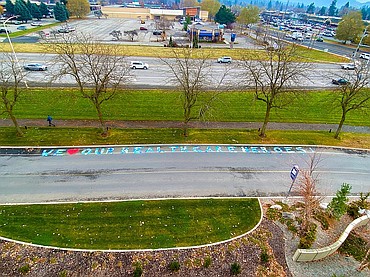 A handful of North Idaho College students spent about fourteen hours working on an appreciation graffiti project for health care workers through a collaboration between the college student government and Kootenai Health. The design was created by student government President Annie Vladovska and was spray painted on the pavement on Kootenai Health Way, on the east side of the hospital. Photo courtesy of Katrina Walker/Kootenai Health
