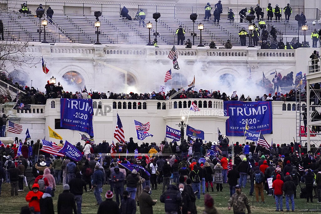 Violent protesters, loyal to President Donald Trump, storm the Capitol on Jan. 6, 2021, in Washington. The Washington Supreme Court heard oral arguments Tuesday, Nov. 9, 2021, in a case that will decide whether the identities of Seattle police officers who attended events in the nation's capital on the day of the insurrection are protected under the state's public records law. (AP Photo/John Minchillo, File)