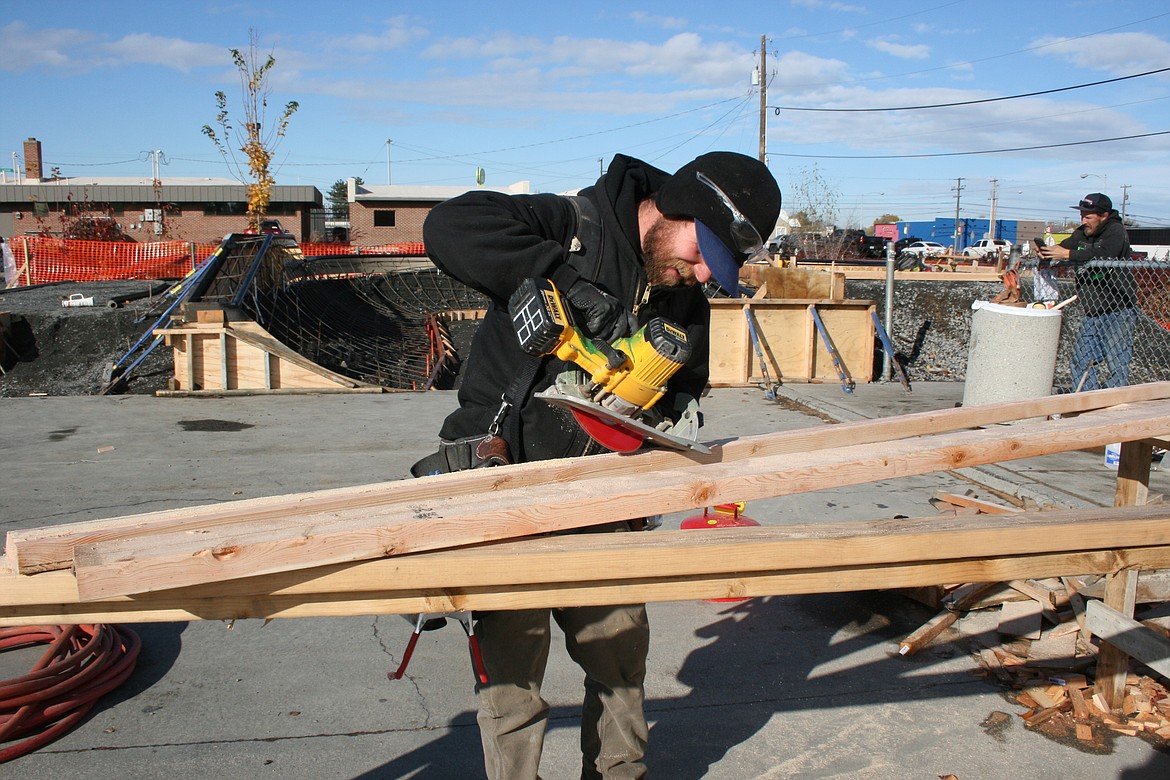 Jack Balerud, of Outer Space Concrete & Construction, trims lumber for a concrete mold at the Moses Lake Skate Park Tuesday.