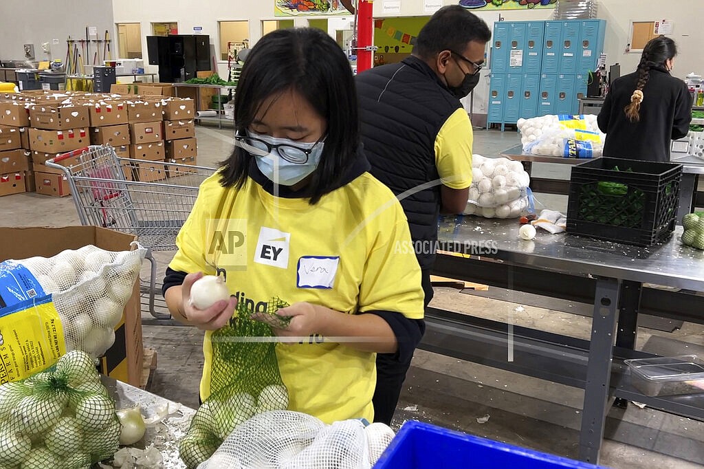 A volunteer packs onions in the warehouse of the Alameda County Community Food Bank in Oakland, Calif., on Nov. 5, 2021. U.S. food banks dealing with increased demand from families sidelined by the pandemic now face a new challenge – surging food prices and supply chain issues. As holidays approach, some food banks worry they won't have enough turkeys, stuffing and cranberry sauce for Thanksgiving and Christmas. Residents picking up free groceries in Oakland said they're grateful for the extra help as the price of dairy, meat and fuel has shot up. (AP Photo/Terry Chea)