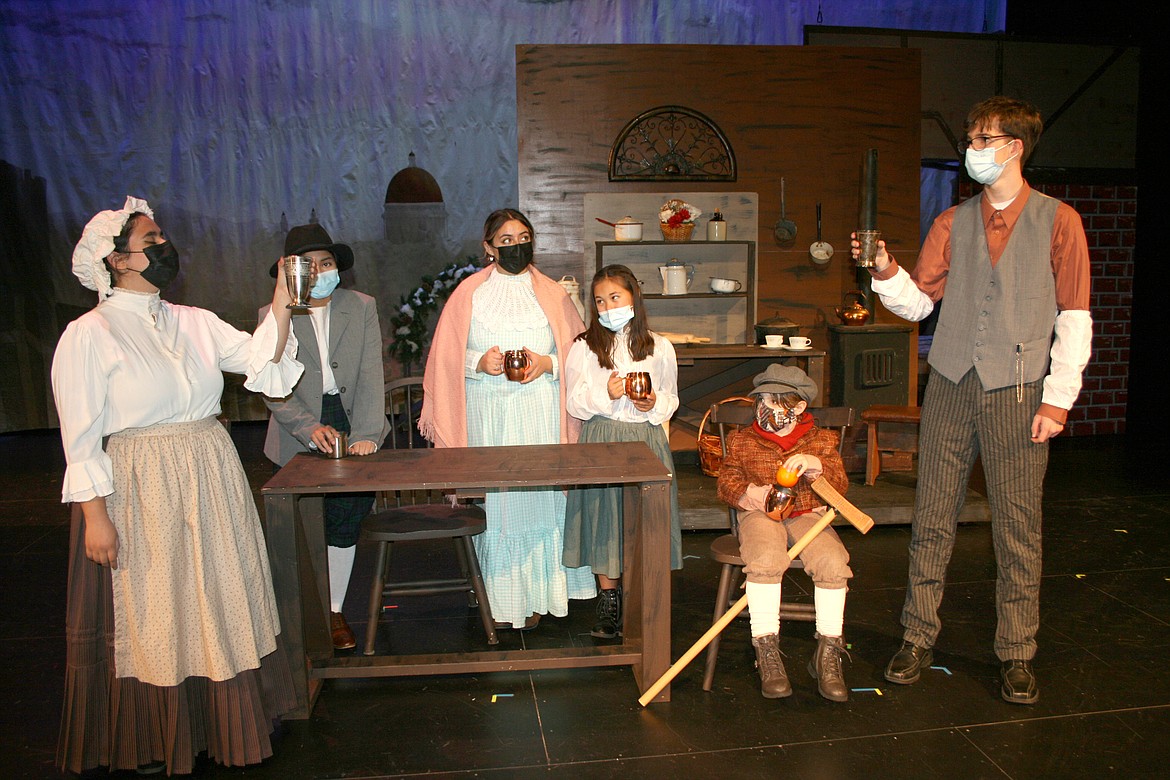 The Cratchit family (from left, Beverly Granados, Nilzelt Gallardo-Reyes, Alicia Lasley, Kimiko Condo, Krysandra Coyle and Cody Kennedy) toast the health of Ebenezer Scrooge - with varying degrees of enthusiasm - during the Quincy High School production of “A Christmas Carol.”