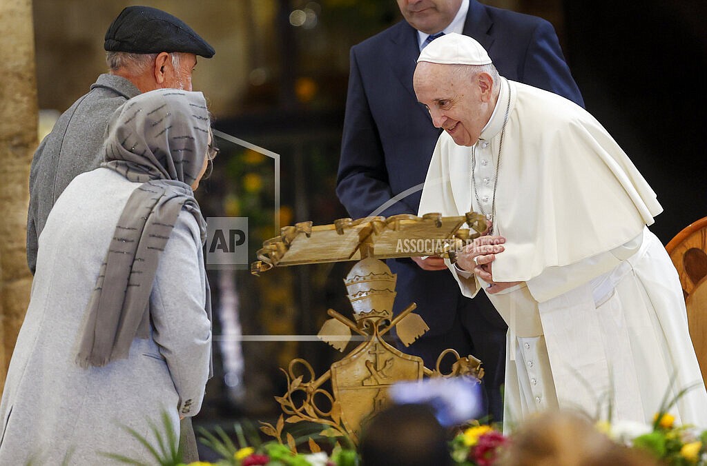 Pope Francis greets Abdul Razaq Quadery, left, and his wife Salima, second from left, two refugees from Afghanistan, at a meeting of listening and prayer inside the Basilica of Santa Maria degli Angeli in Assisi, central Italy, Friday, Nov. 12, 2021. Pope Francis met a group of 500 poor people from different parts of Europe ahead of the fifth World Day of the Poor on Sunday. (AP Photo/Riccardo De Luca)