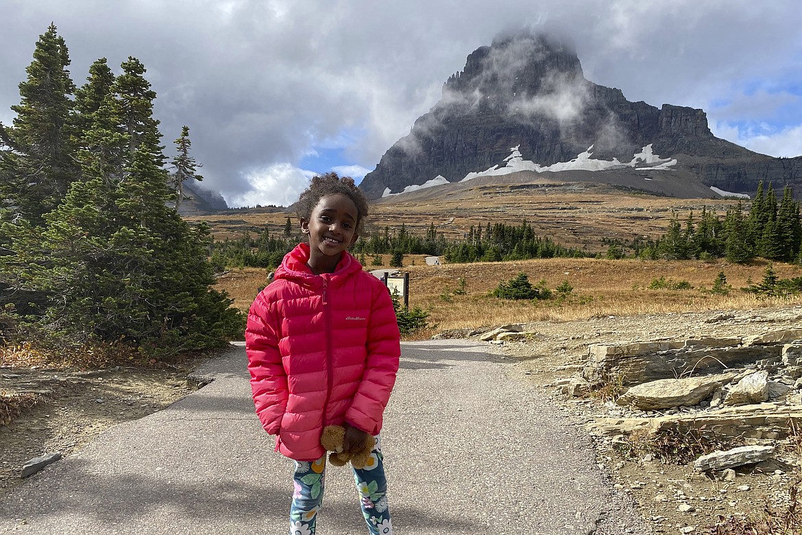 In this photo provided by Ben Pascal, five-year-old Naomi Pascal, holding her teddy bear, is pictured on a hike to Hidden Lake in Glacier National Park, Mont., in October 2020. Naomi lost the bear while on the hike, but it was found by a park ranger who took care of the bear until it was spotted on the dash of his ranger truck and returned to Naomi this fall. (Ben Pascal via AP)