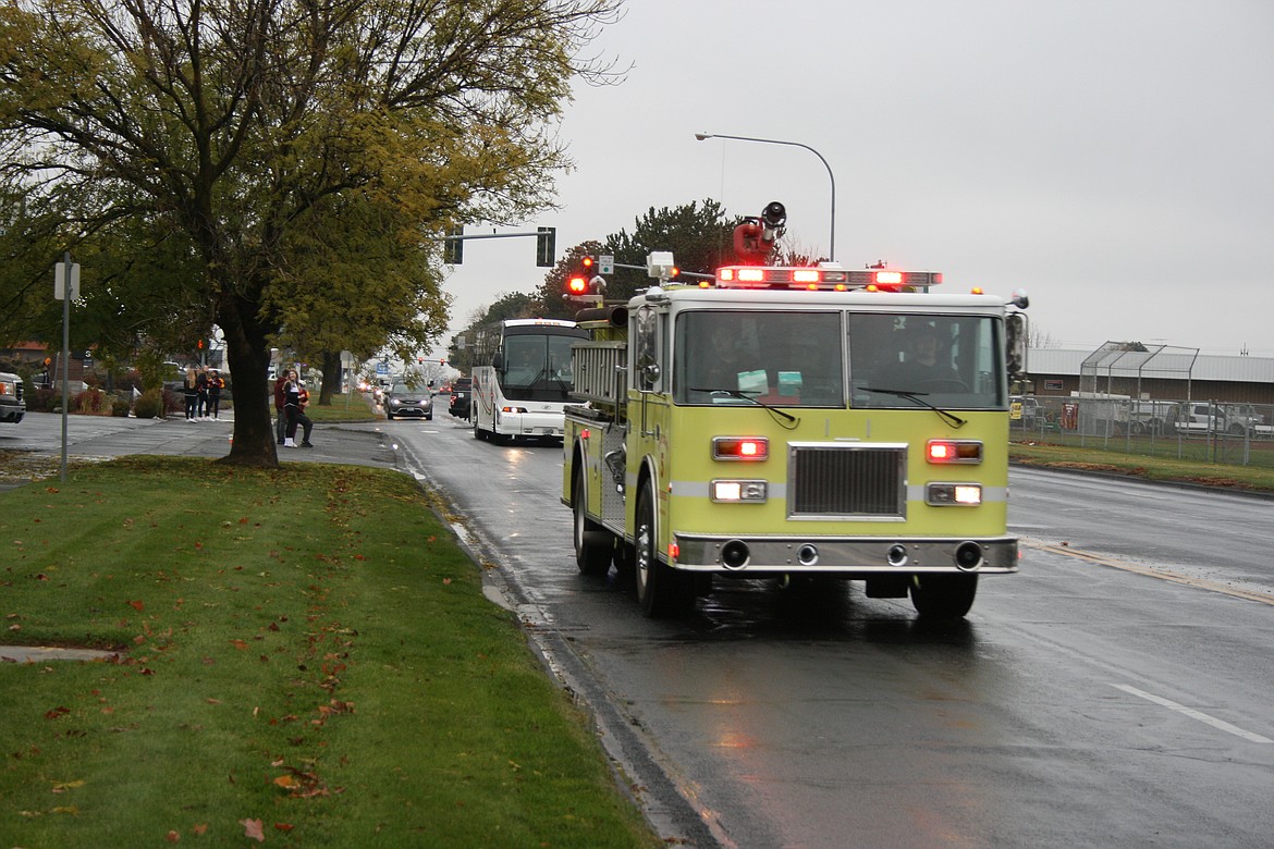 A truck from Grant County Fire District 5 escorts the buses carrying the Moses Lake High School football team on Pioneer Way toward Interstate 90 to the team's first state playoff game since 2017.