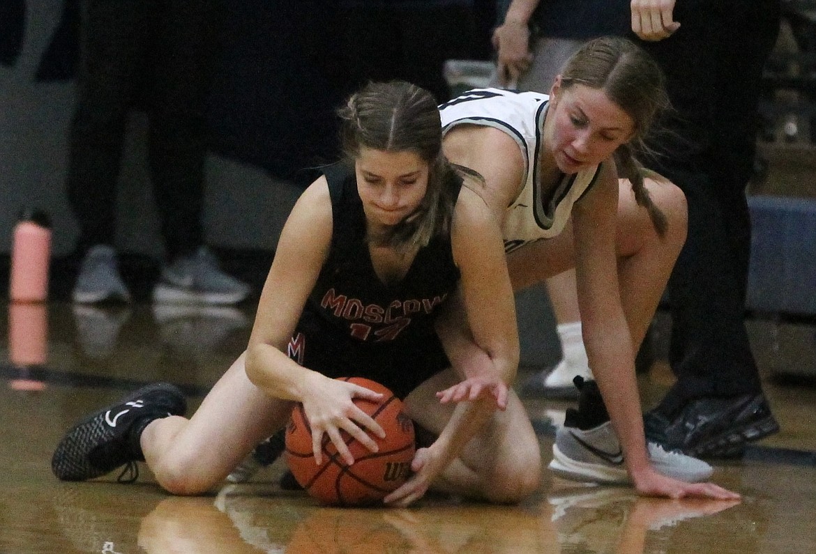 MARK NELKE/Press
Avery Waddington, right, of Lake City, reaches in as Kennedy Thompson (12) of Moscow tries to secure the ball Saturday at Lake City.