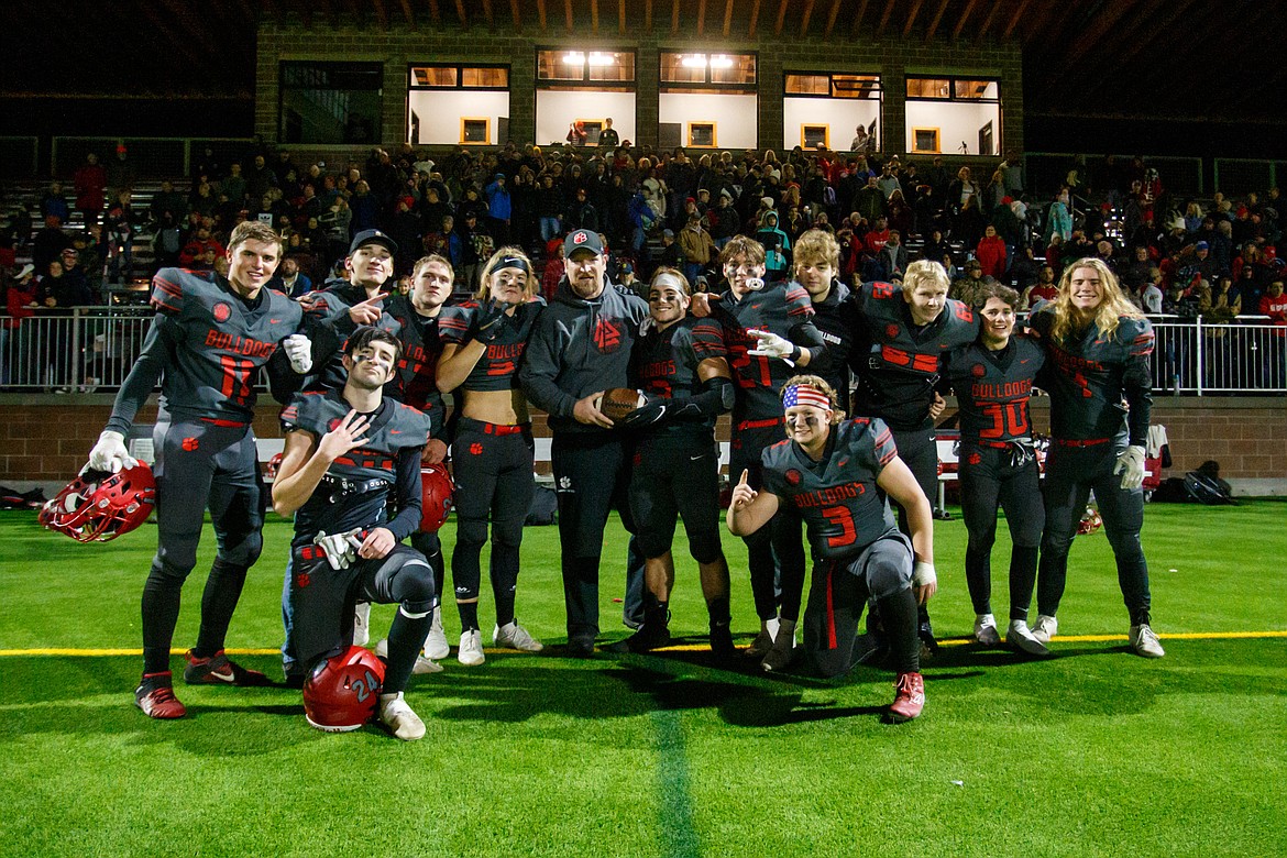 Head coach Ryan Knowles poses for a photo with the seniors after their last game at War Memorial Field.