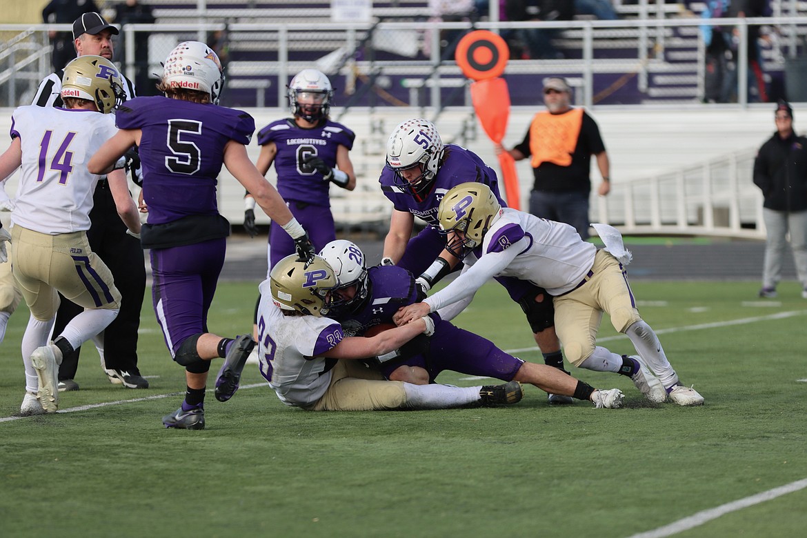 Keyen Nash (33) and Jarrett Wilson (8) wrap up Laurel running back Beau Dantic as Brock Henriksen (14) closes in. (Courtesy of Niki Graham)