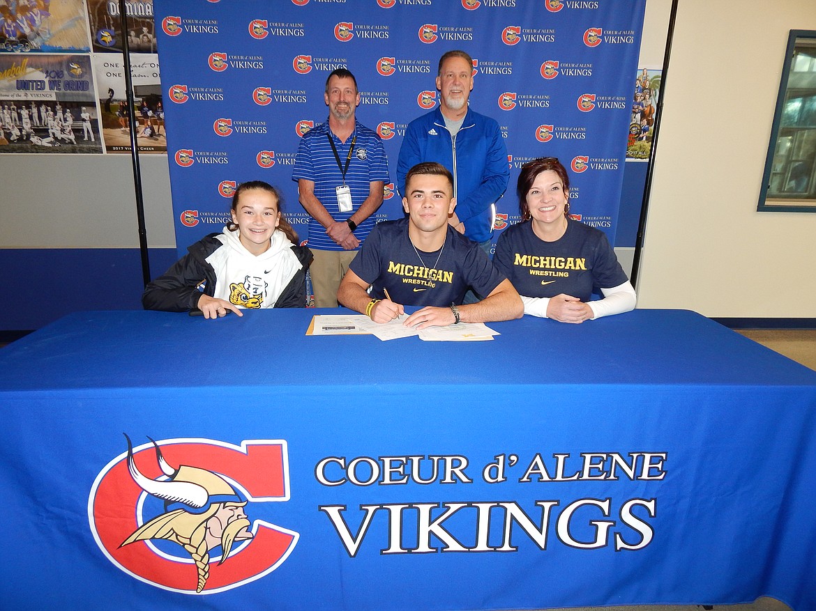 Courtesy photo
Coeur d'Alene High senior Rylan Rogers recently signed a letter of intent to wrestle at the University of Michigan. Seated from left are Roxie Rogers, sister; Rylan Rogers and Nikki Rogers, mom; and standing from left, Bill White, Coeur d'Alene High athletic director; and Jeff Moffat, Coeur d'Alene High head wrestling coach.