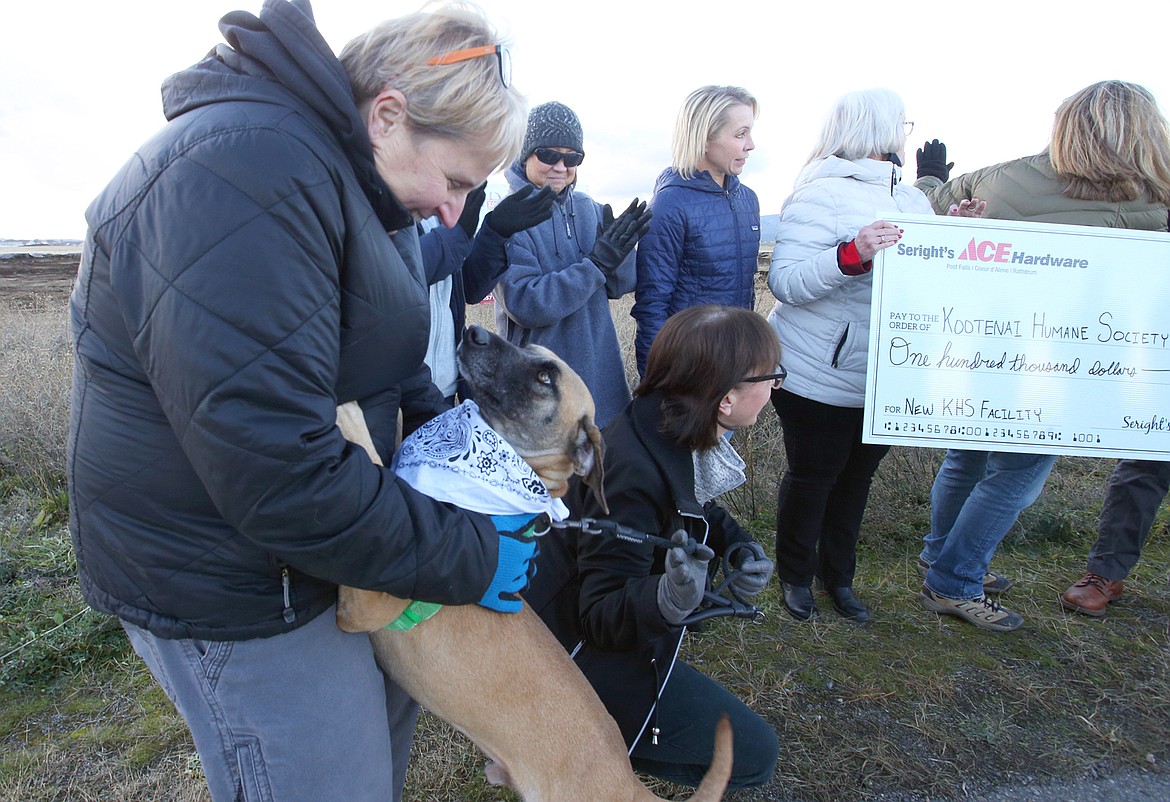 Kootenai Humane Society Board Member Denise Morris is greeted by Cooper, a five-year-old hound mix, at Tuesday's groundbreaking off Atlas Road for the KHS new shelter.