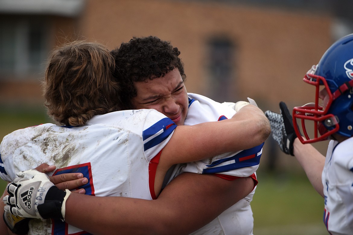 Bigfork’s George Brown hugs teammate Patrick Wallen as the Vikings celebrate their 7-3 win at Eureka in the state semifinals Saturday. (Jeremy Weber/Bigfork Eagle)