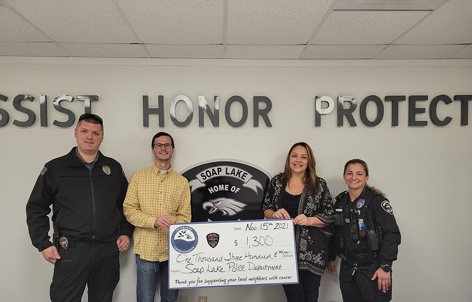 From the left, Soap Lake Police Department Chief Ryan Cox, Soap Lake Mayor Alex Kovach, Columbia Basin Cancer Foundation Executive Director Angel Ledesma and SLPD Officer Tegan Peek pose Monday with a $1,300 check donation.