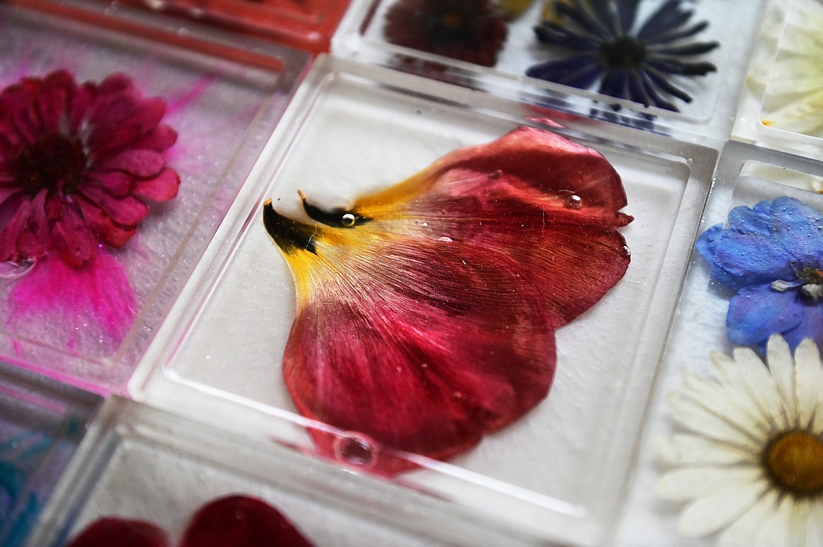 Lindsay Mena, president of Artists and Craftsmen of the Flathead, grows her own flowers and encases them in epoxy resin to create colorful coasters, stove spoon rests, nightlights, keychains and more. (Casey Kreider/Daily Inter Lake)