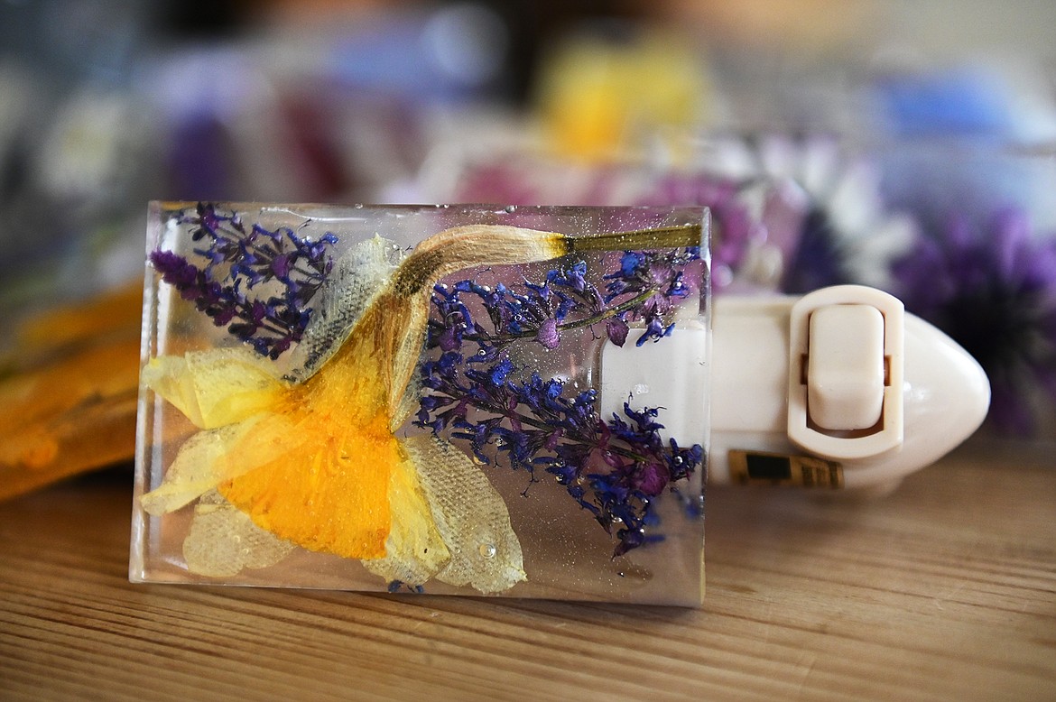 Lindsay Mena, president of Artists and Craftsmen of the Flathead, grows her own flowers and encases them in epoxy resin to create colorful coasters, stove spoon rests, nightlights, keychains and more. (Casey Kreider/Daily Inter Lake)