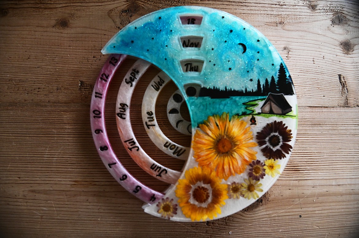 A lunar calendar created by Lindsay Mena, president of Artists and Craftsmen of the Flathead, using flowers she grows herself encased in epoxy resin. (Casey Kreider/Daily Inter Lake)