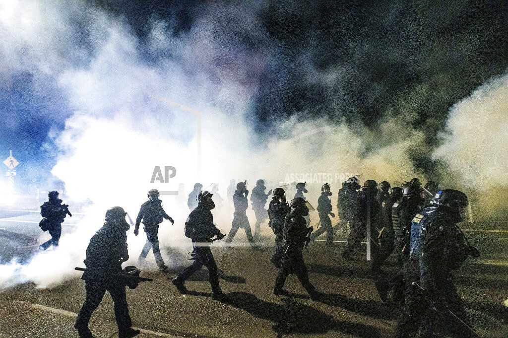 In this Sept. 5, 2020, file photo, police use chemical irritants and crowd control munitions to disperse protesters during a demonstration in Portland, Ore. A year after Portland's police department underwent significant budget cuts amid demands to defund the police, the city is looking to spend more than $5 million for police investments, including hiring more officers and buying body-worn cameras. (AP Photo/Noah Berger, File)