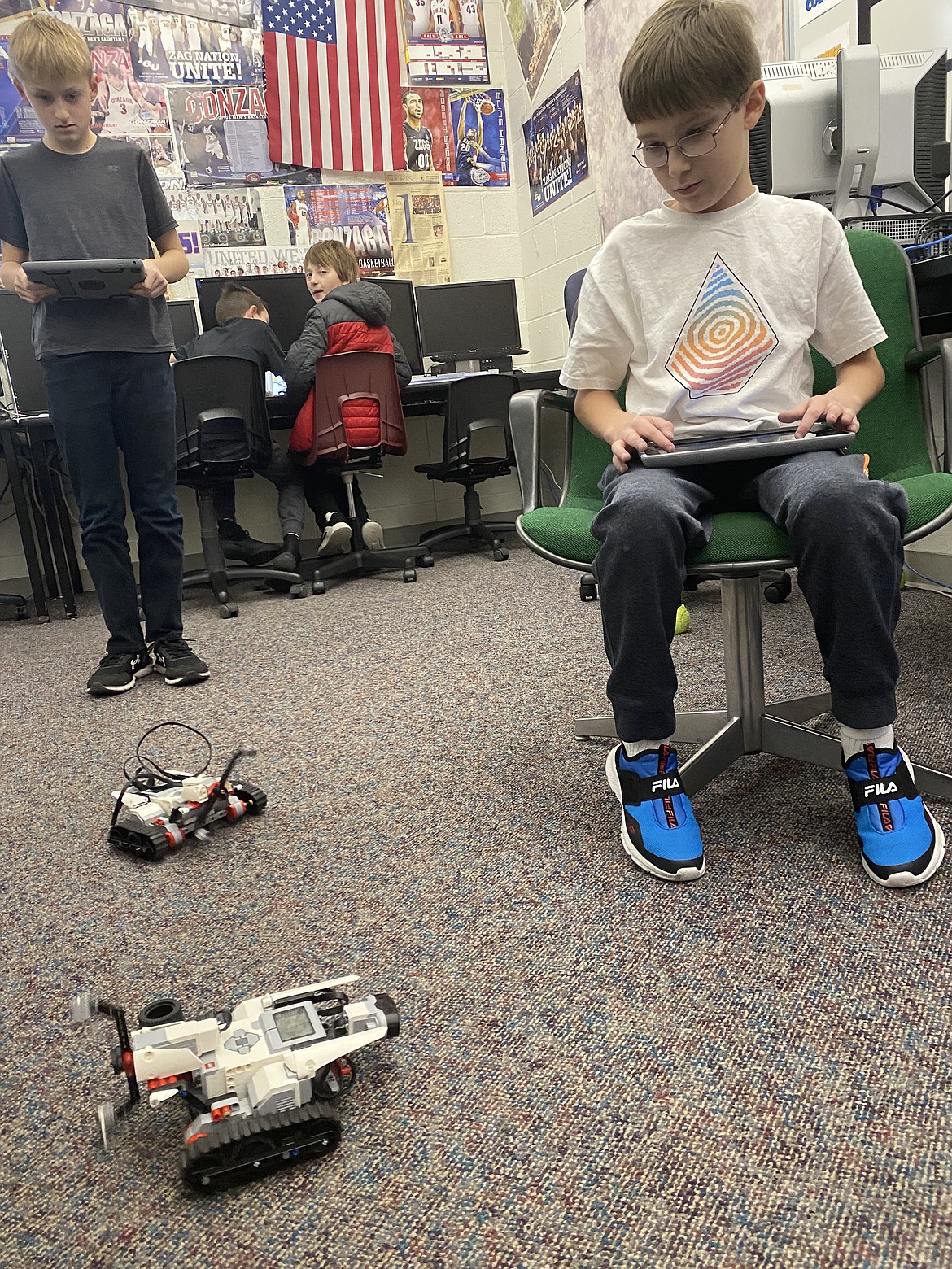 From left: River City Middle School students Jack Robertson, 12, and Seth Harrison, 11, engage in some healthy competition Friday, with their robots which are operated via Bluetooth. Robotics kits were made possible by a Post Falls Education Grant.
