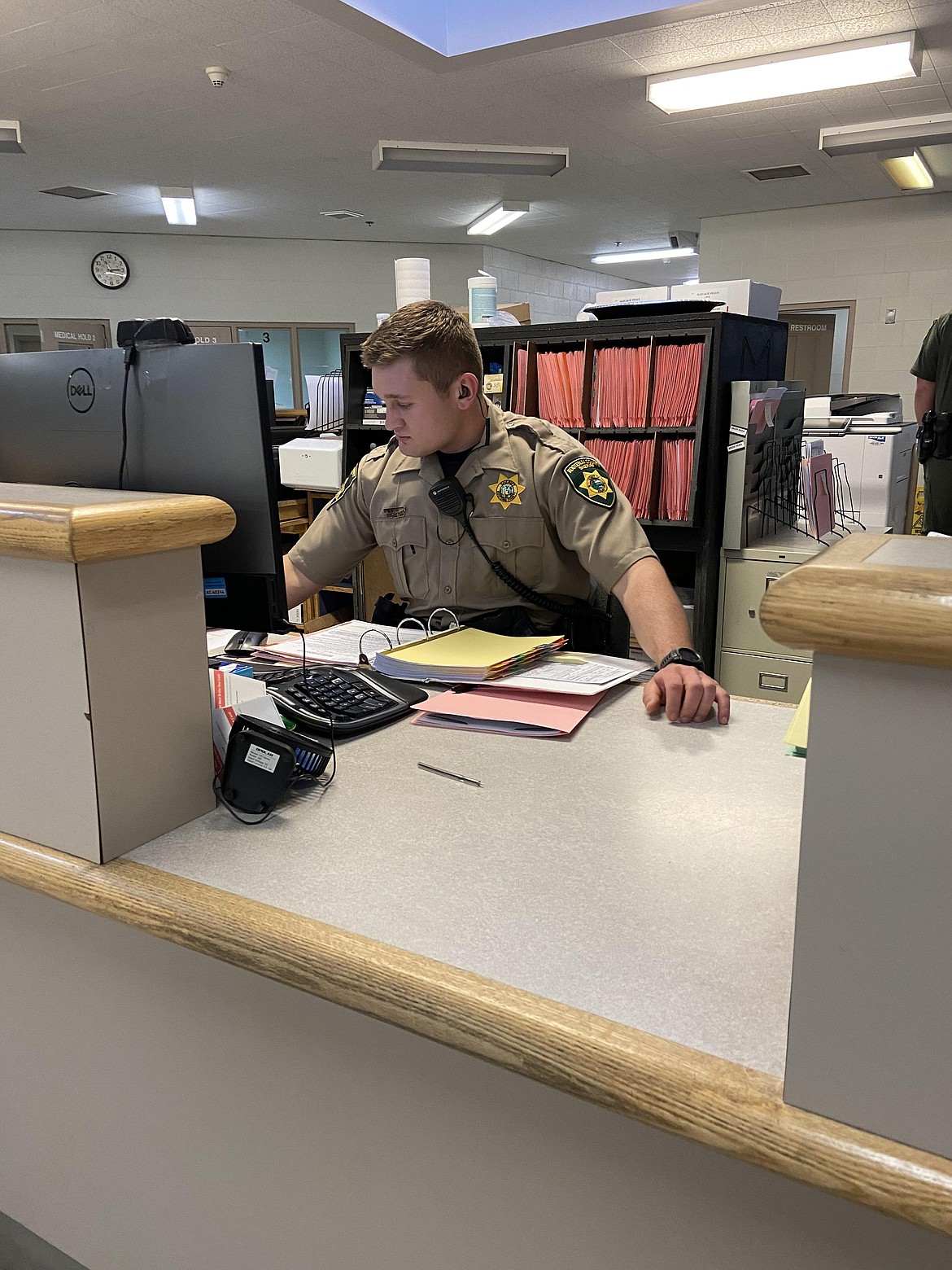 Kootenai County Sheriff’s Office Deputy Tipolt mans a desk at the Kootenai County Jail, where officials say staff shortages can create an unsafe environment. Courtesy photo.