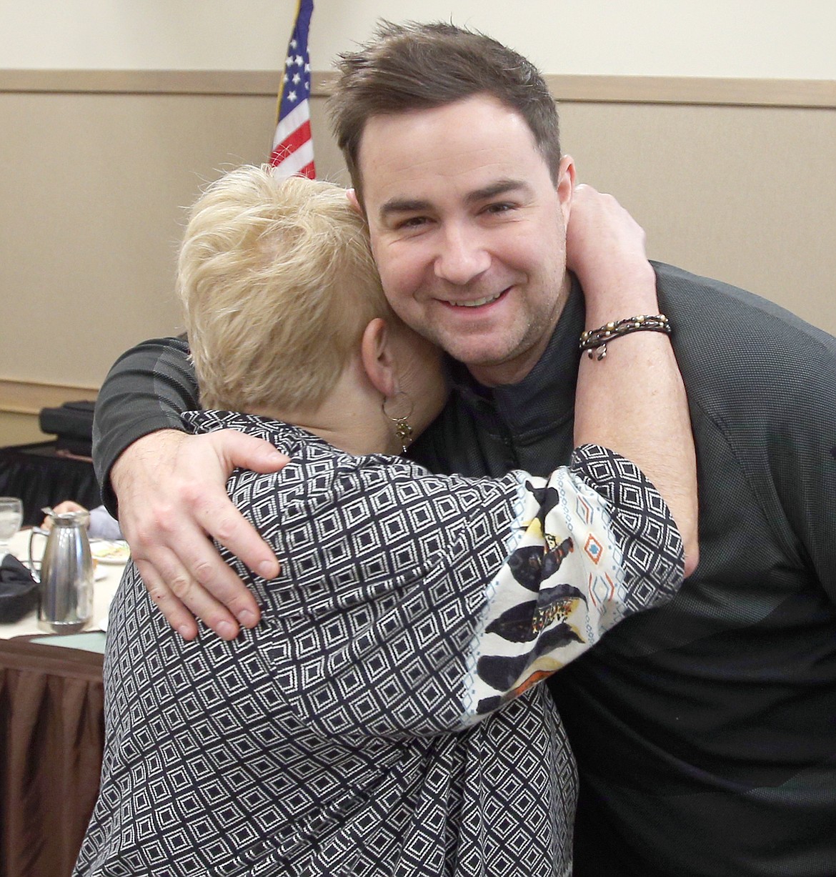 Mick O'Neill, Best Western Plus Coeur d'Alene Inn banquet manager, gets a hug from Earlee Young, Rambling Rovers president, on Thursday.