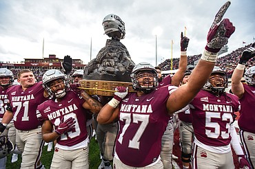Montana celebrates with the Great Divide Trophy after a 29-10 win over Montana State in the 120th Brawl of the Wild at Washington-Grizzly Stadium on Saturday, Nov. 20. (Casey Kreider/Daily Inter Lake)