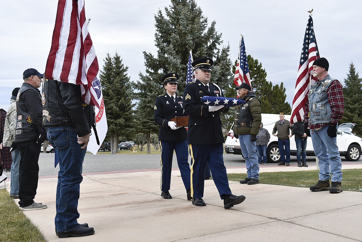 The remains of Army Spc. Michael J. Gilmer are escorted into a funeral ceremony on Thursday, Nov. 18, 2021, at the Montana State Veteran's Cemetery near the VA Medical Center at Fort Harrison, west of Helena, Mont. Officials at the medical center were unable to find any of Gilmer's family members, so hospital workers and area veterans attended his memorial service. (Thom Bridge/Independent Record via AP)