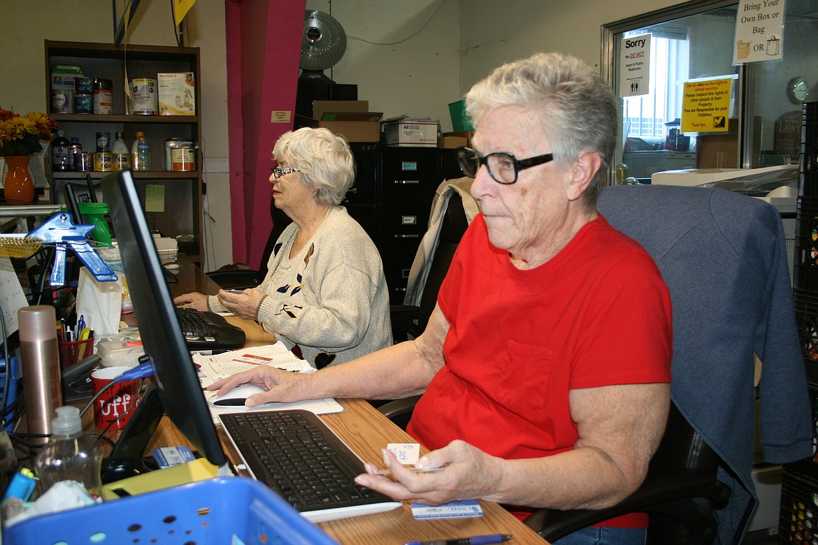 Karen Zerby checks the card of a Moses Lake Food Bank customer. Zerby volunteers three days per week.