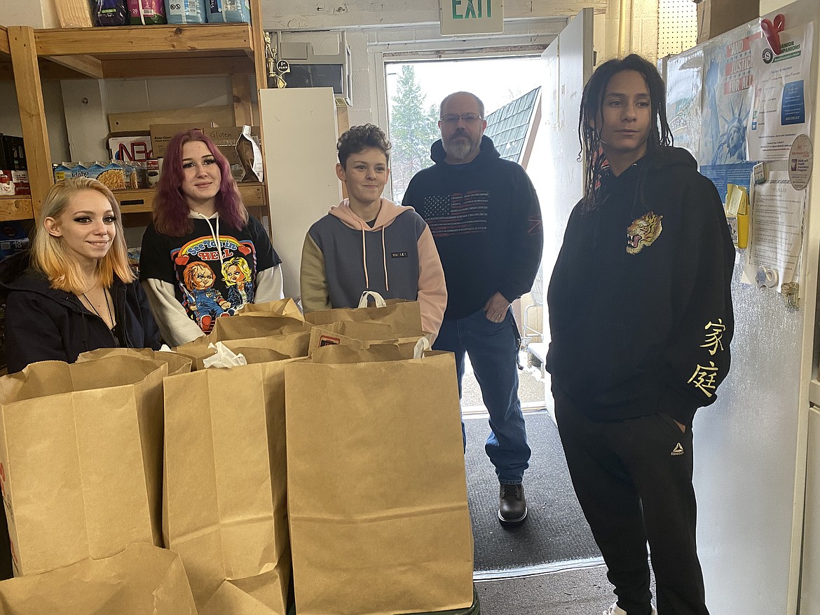 From left: T'Kyah Knutson, 16, Kylie Kindy, 17, Molly Willard, 16, Principal Paul Uzzi and Ronji Olivieri, 14, stand in the Rathdrum Food Bank Friday, waiting to collect packages of food to distribute to students who need help over the Thanksgiving holiday this week.