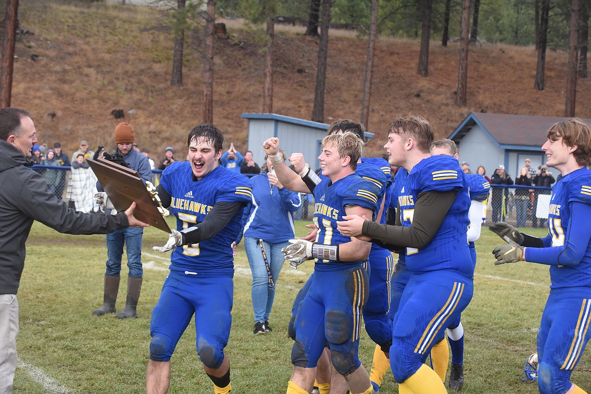 Thompson Falls senior Nathan Schraeder (5) leads the way to accept the trophy for winning the 2021 Montana 8-man football championship last Saturday at Previs Field. The Blue Hawks beat the Flint Creek Titans, 40-8. (Scott Shindledecker/Valley Press)