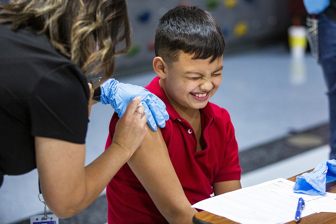 Iker Santiago-Sias, 10, cringes as Ector County ISD RN Joanna Muniz, left, administers a Pfizer COVID-19 vaccine at Zavala Elementary School Wednesday, Nov. 10, 2021, in Odessa, Texas. (Jacob Ford/Odessa American via AP)