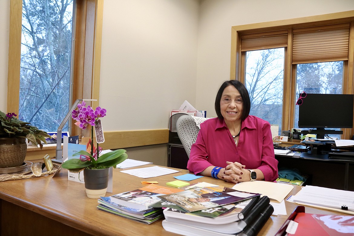 Retiring Vice President of Instruction Lita Burns sits among gifted plants and paperwork at her desk at North Idaho College. HANNAH NEFF/Press