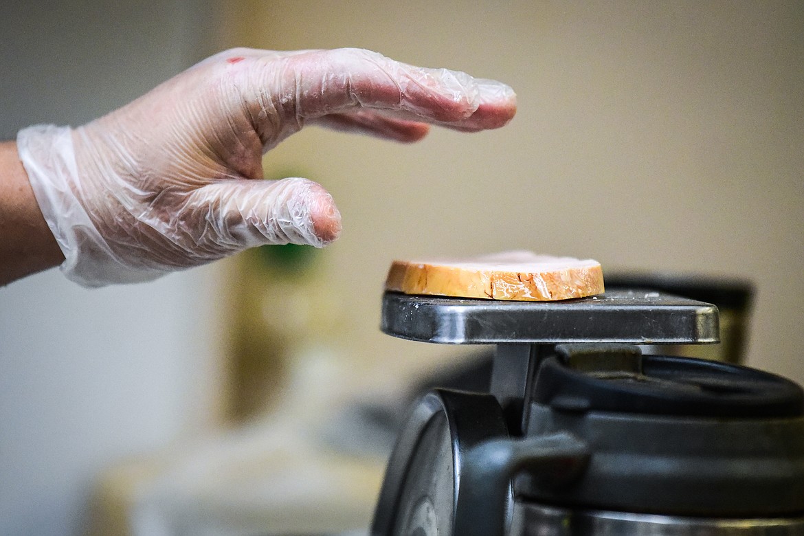 Erik Anderson weighs slices of turkey in preparation for the Thanksgiving dinner at Syke's Diner on Tuesday, Nov. 23. (Casey Kreider/Daily Inter Lake)