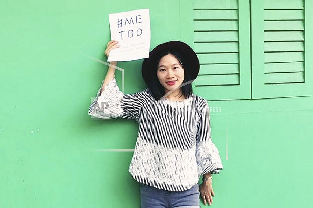 In this photo released by #FreeXueBing, Huang Xueqin holds up a #METOO sign for a photo in Singapore on Sept. 2017. Huang, who publicly supported a woman when she accused a professor of sexual assault, was arrested in September. In China, Huang is just one of several people, activists and accusers alike, who have been hustled out of view, charged with crimes or trolled and silenced online for speaking out about the harassment, violence and discrimination women face every day. (#FreeXueBing via AP)