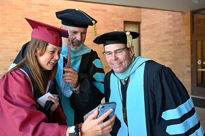 From left, former NIC student Jestine Lackner shows Vice President of Student Services Graydon Stanley and former President Rick MacLennan a selfie with the president during the 2021 commencement walk. Photo courtesy of North Idaho College.