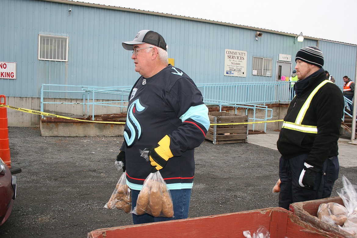 Rich Howard, left, waits to give potatoes during the Thanksgiving distribution drive-thru at the Moses Lake Food Bank Monday.