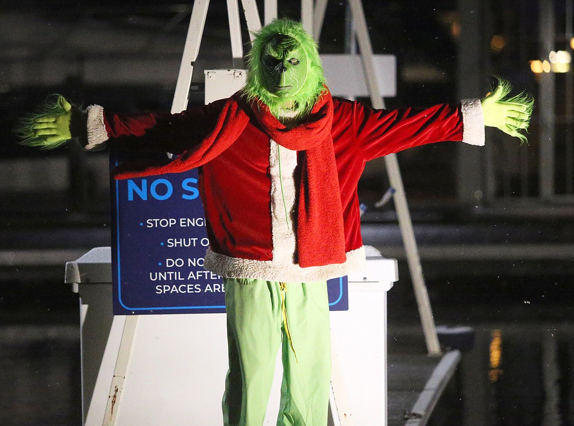 The Grinch gives visitors the business as they head out on a cruise across Lake Coeur d’Alene to the North Pole from The Coeur d’Alene Resort Tuesday night.