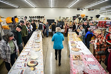 Attendees bid on pies during the silent auction at Light Up Evergreen & Pie Auction at The Hardware Store on Tuesday, Nov. 23. (Casey Kreider/Daily Inter Lake)