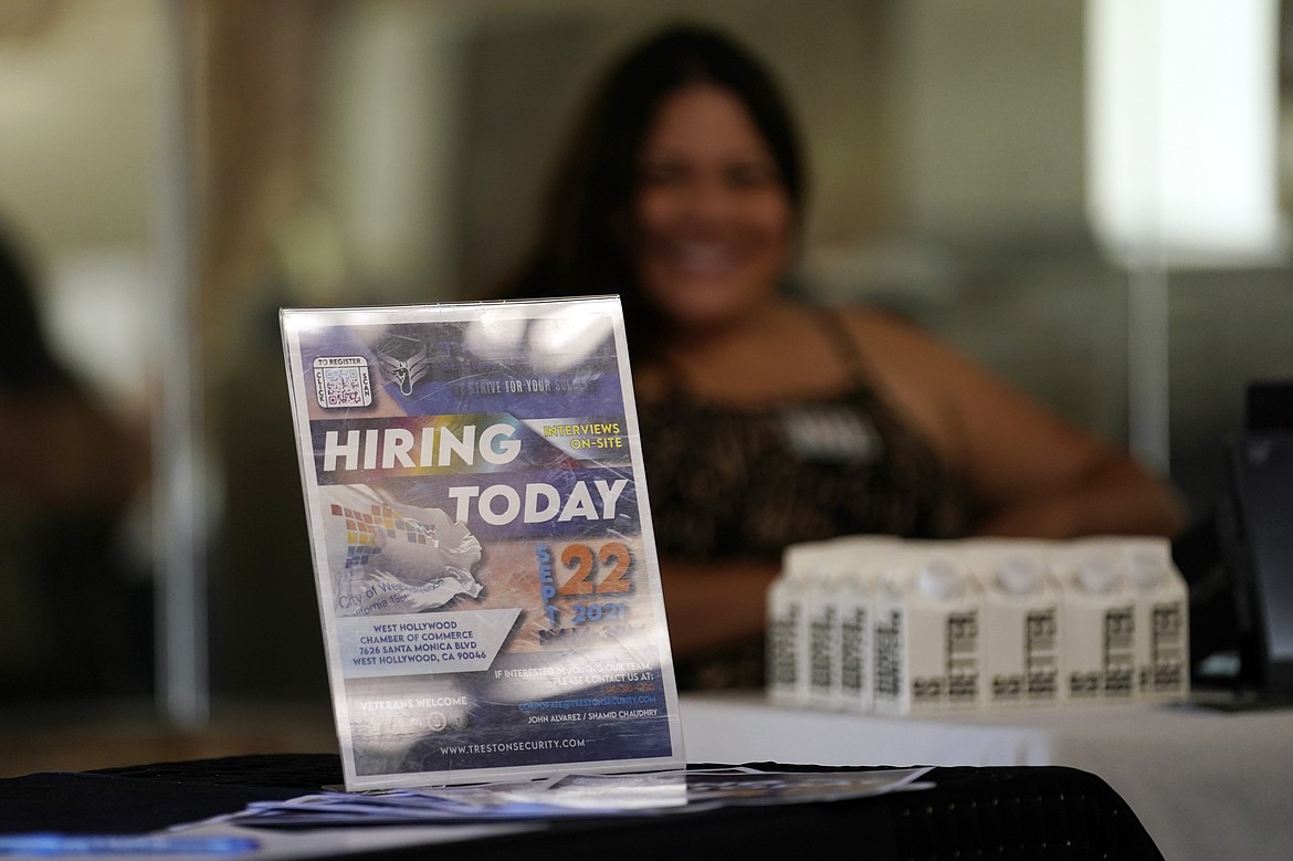 A hiring sign is placed at a booth for prospective employers during a job fair Sept. 22 in the West Hollywood section of Los Angeles.