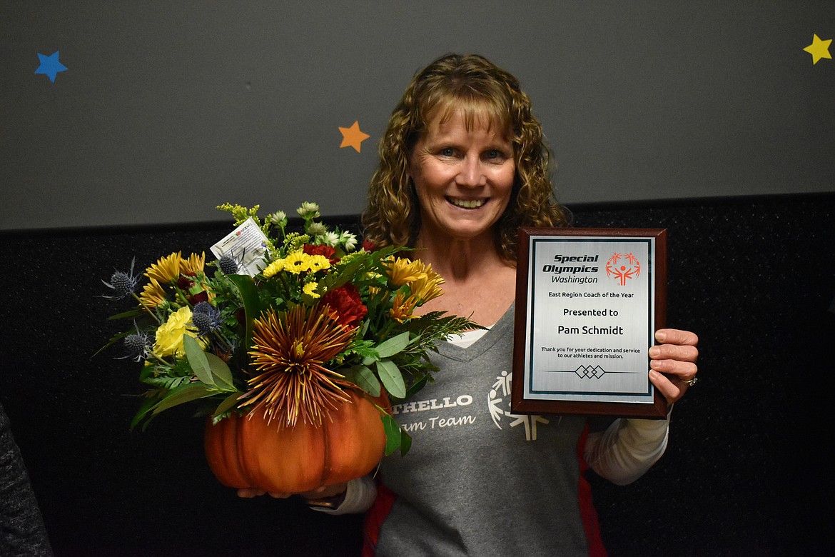 Pam Schmidt, who coached the Othello Dream Team Special Olympics bowling team and the combined Othello and Moses Lake Special Olympics bowling team, holds her East Region Coach of the Year plaque from Special Olympics Washington and flowers.